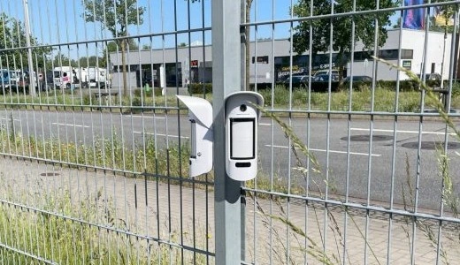 Perimeterabsicherung; Zwei Überwachungskameras an einem Zaun